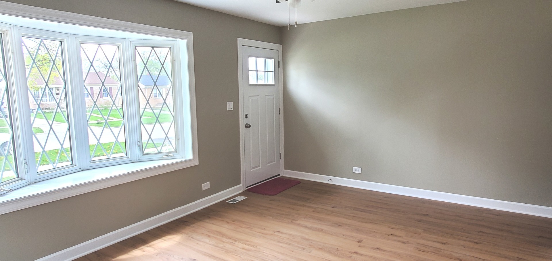 1241 Howard Avenue Berkeley, IL 60163 - Photo 3 of 14 a view of an empty room with wooden floor and a window