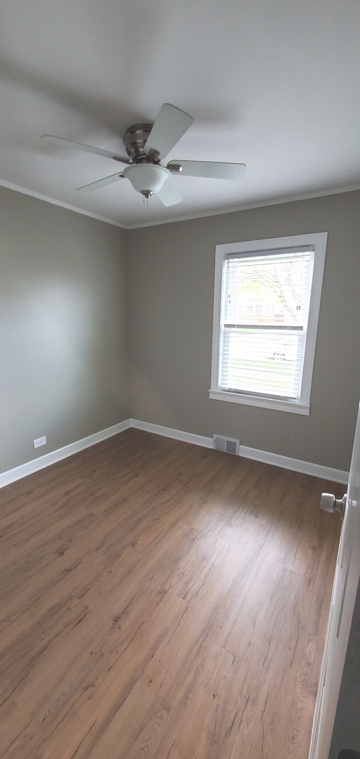 1241 Howard Avenue Berkeley, IL 60163 - Photo 7 of 14 an empty room with wooden floor and windows