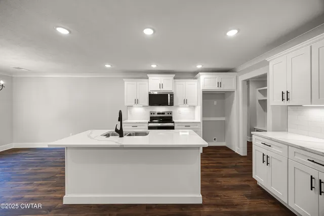 a view of an empty room with wooden floor fireplace and a window