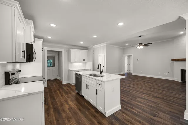 a kitchen with a sink stainless steel appliances and white cabinets