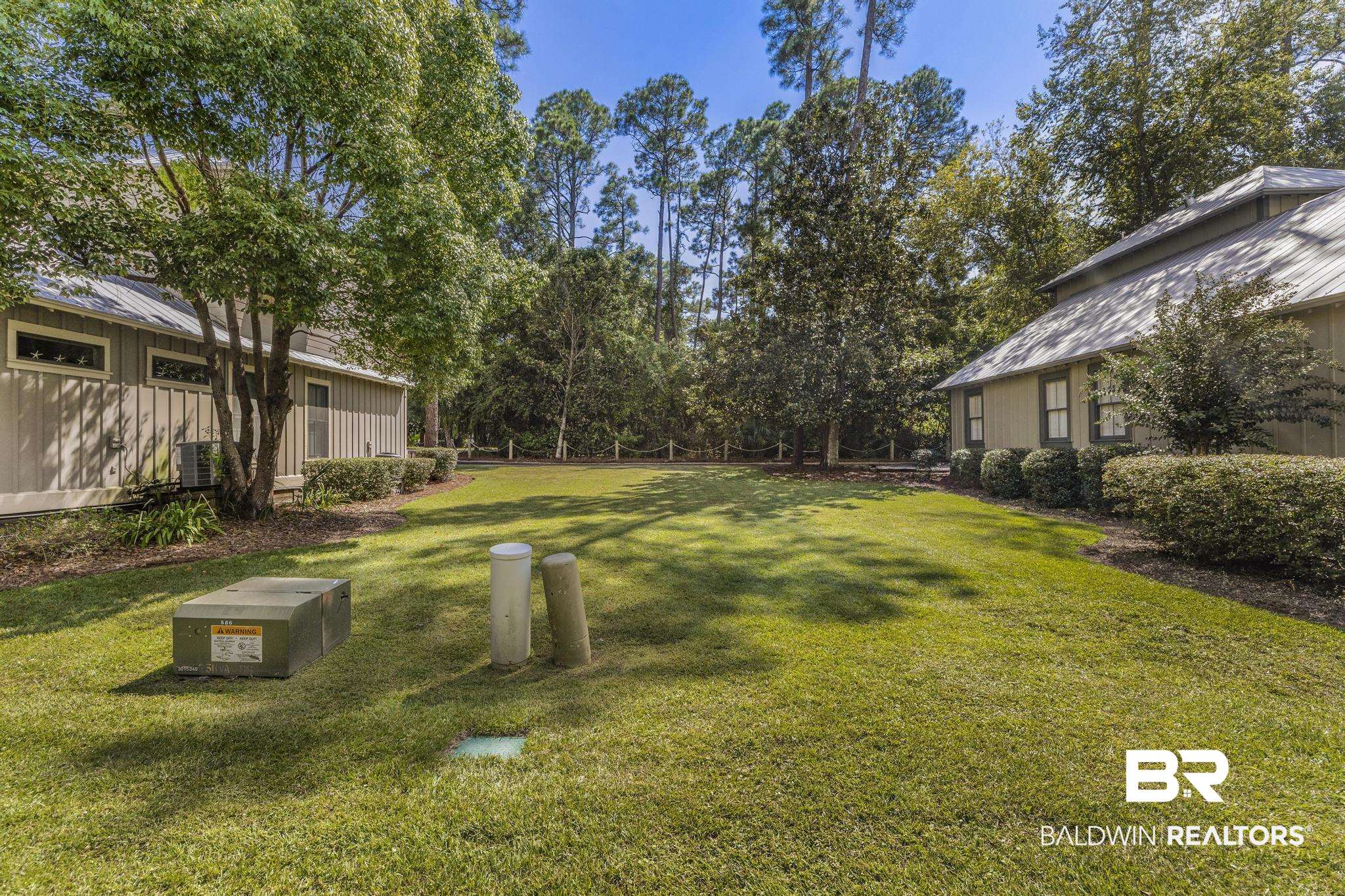 25773 Canal Road Orange Beach, AL 36561 - Photo 4 of 32 View of green lawn with view of wooded area