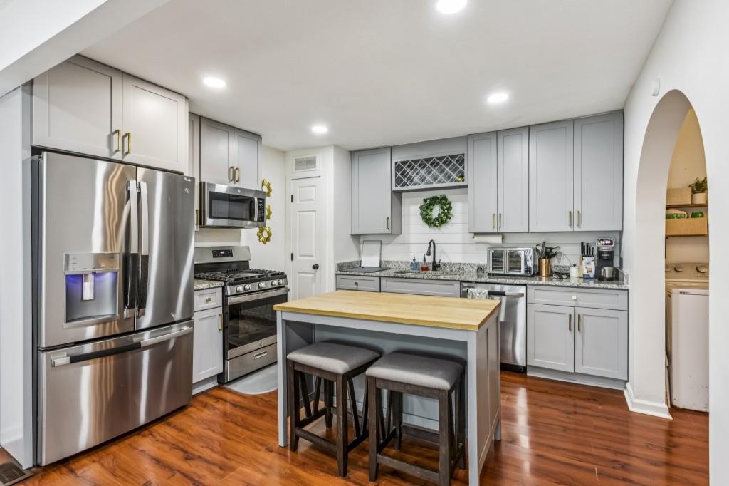 5430 Carol Circle Southwest Mableton, GA 30126 - Photo 3 of 32 a kitchen with stainless steel appliances granite countertop a refrigerator a stove a sink a dining table and chairs
