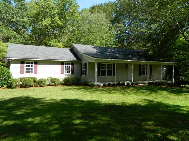 a view of a house with a yard and porch
