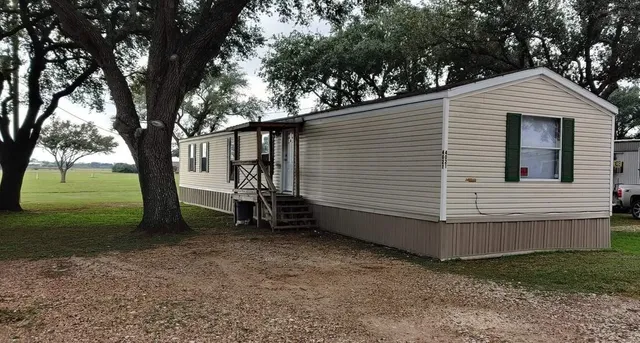a view of backyard with wooden fence and a large tree