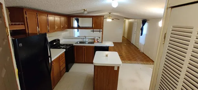 a kitchen with kitchen island a sink stove and refrigerator