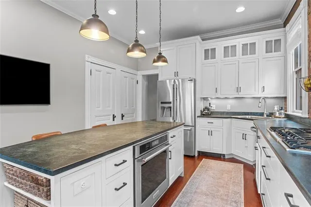 a kitchen with stainless steel appliances granite countertop a stove refrigerator sink and cabinets