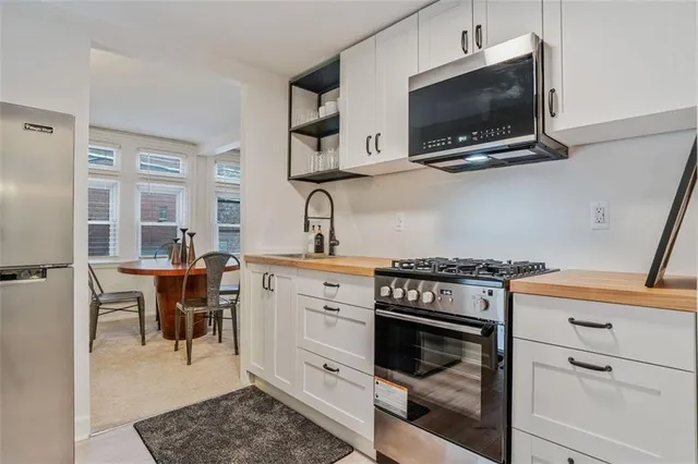 a kitchen with stainless steel appliances granite countertop a stove and a refrigerator