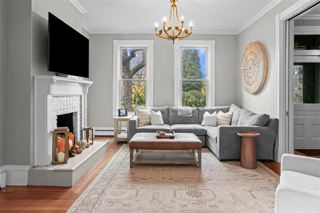 a living room with furniture a chandelier and a large window