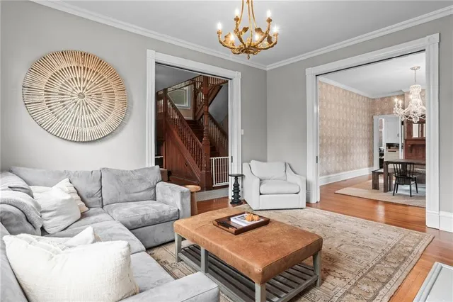 a view of a dining room with furniture a chandelier and wooden floor
