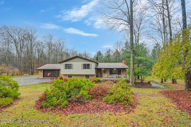 a front view of a house with a yard and large trees