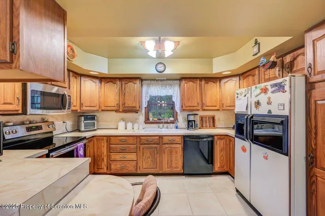 a kitchen with stainless steel appliances a stove a sink and a refrigerator