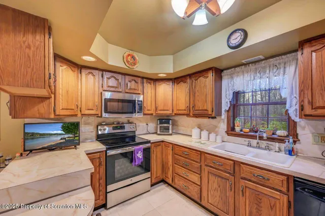 a view of a dining room with furniture a chandelier and large windows