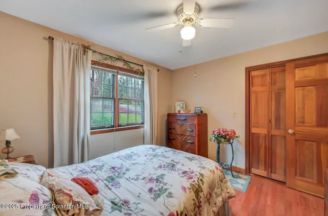a living room with furniture a ceiling fan and a large window