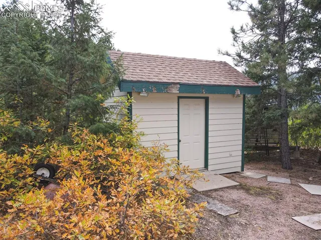 a view of a yard with plants and wooden fence