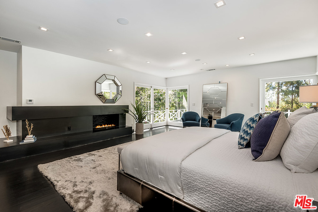 243 Delfern Drive Los Angeles, CA 90077 - Photo 16 of 32 a large bedroom with a bed and a fireplace