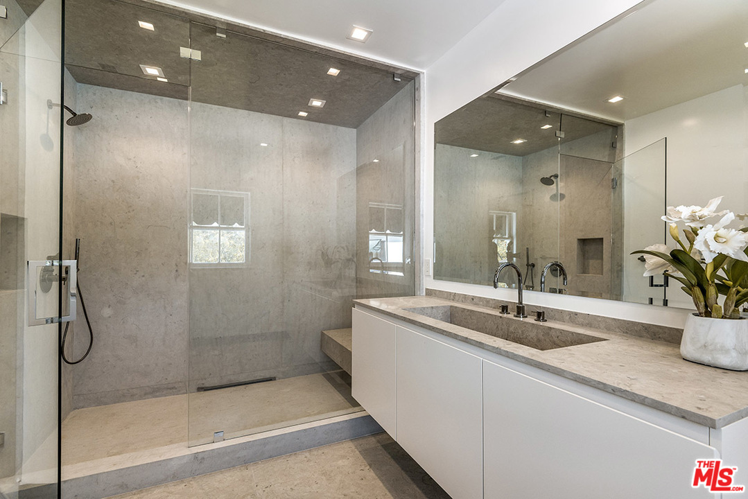243 Delfern Drive Los Angeles, CA 90077 - Photo 24 of 32 a bathroom with a shower sink and mirror