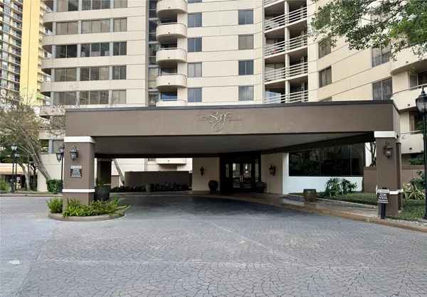 a front view of a building with glass windows and garage