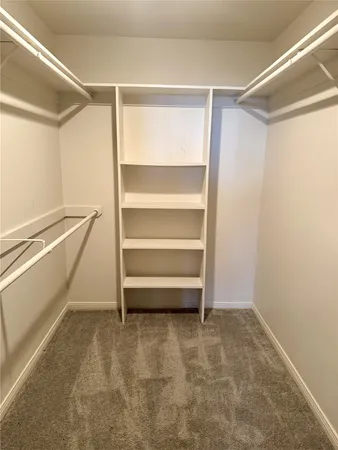 a view of walk in closet with empty racks