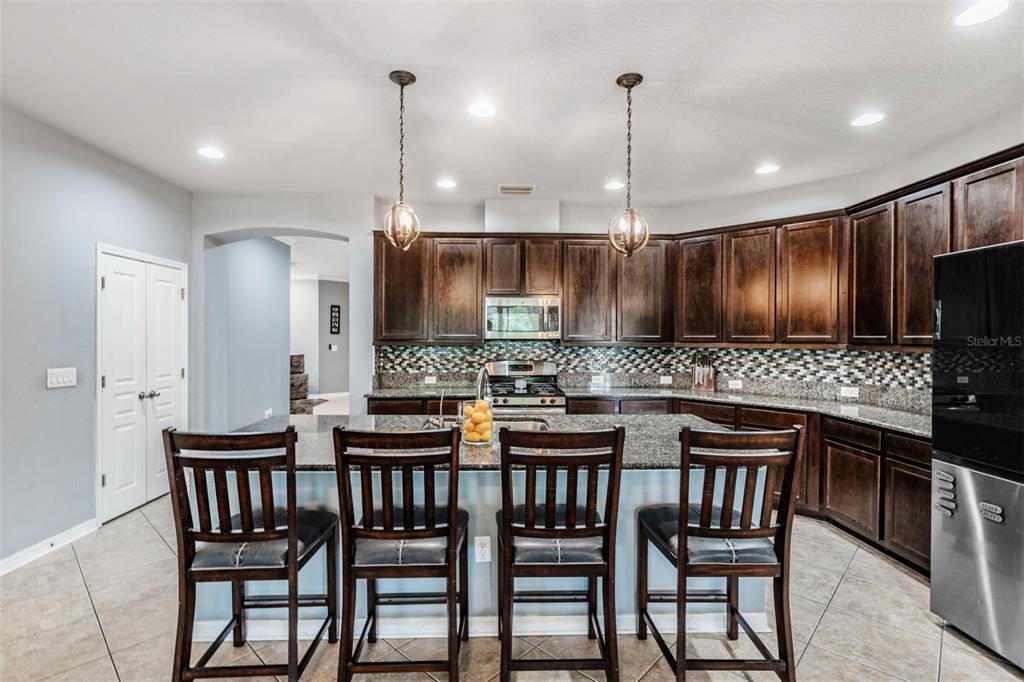 6908 Covington Stone Avenue Apollo Beach, FL 33572 - Photo 12 of 60 a kitchen with a table and chairs in it