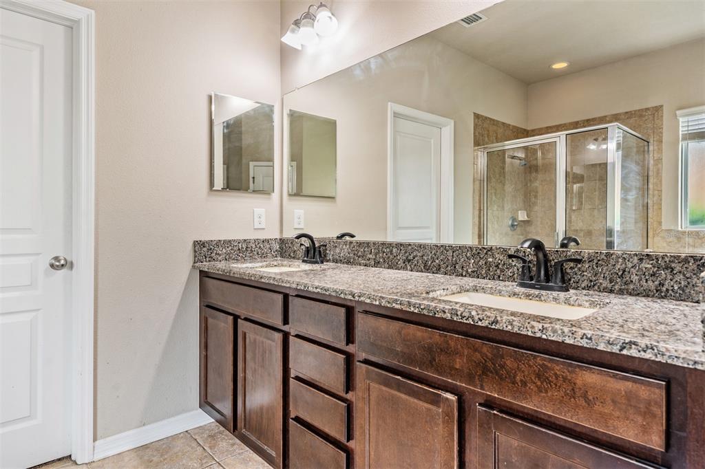 6908 Covington Stone Avenue Apollo Beach, FL 33572 - Photo 24 of 60 a bathroom with a granite countertop sink and a mirror