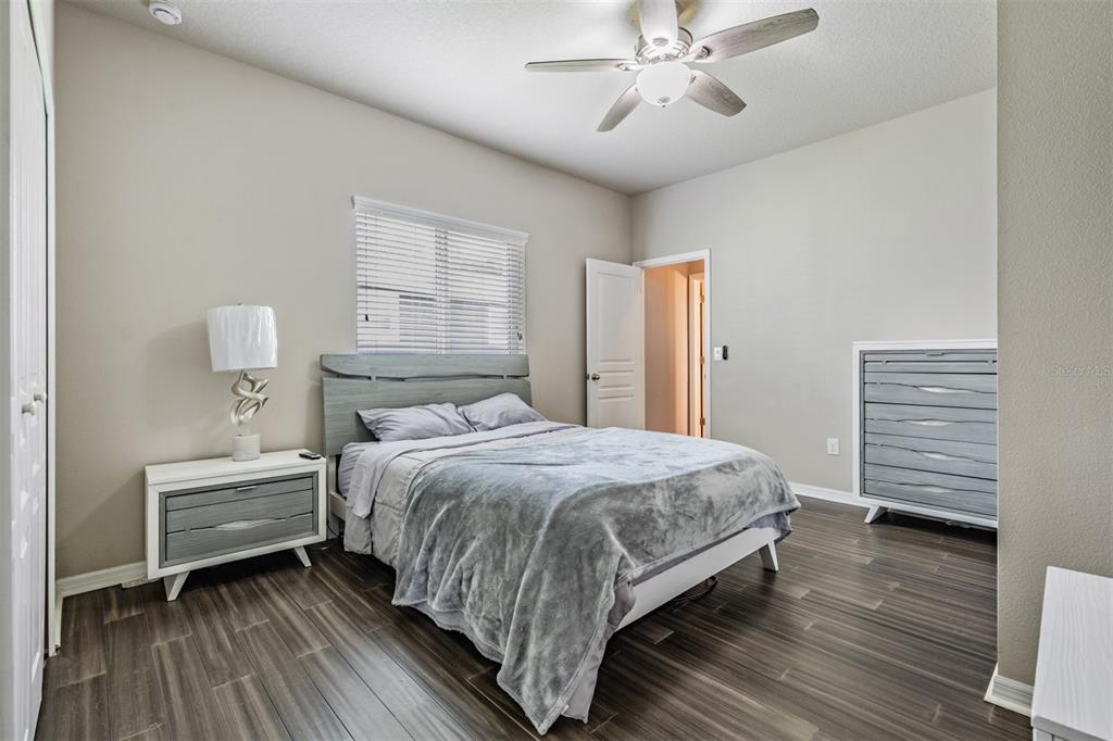 6908 Covington Stone Avenue Apollo Beach, FL 33572 - Photo 25 of 60 a bedroom with a bed and a chandelier