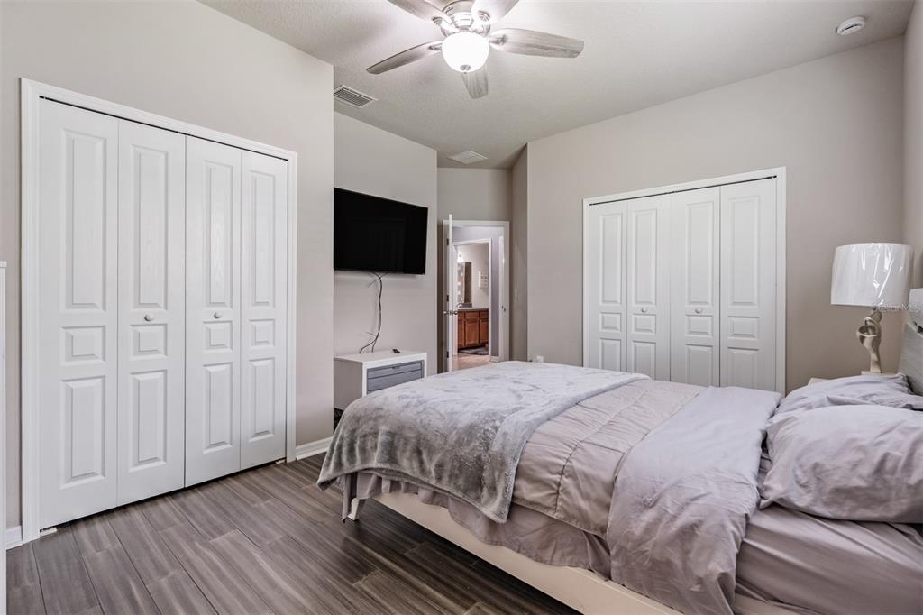 6908 Covington Stone Avenue Apollo Beach, FL 33572 - Photo 26 of 60 a bedroom with a bed and a flat screen tv