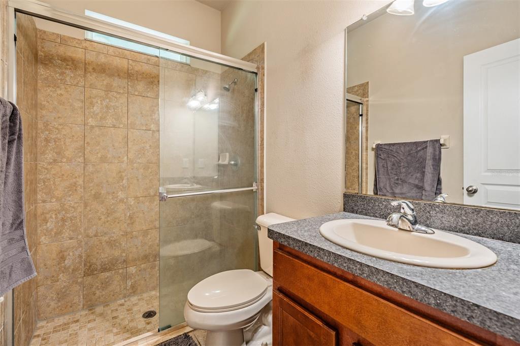 6908 Covington Stone Avenue Apollo Beach, FL 33572 - Photo 28 of 60 a bathroom with a granite countertop sink toilet and shower