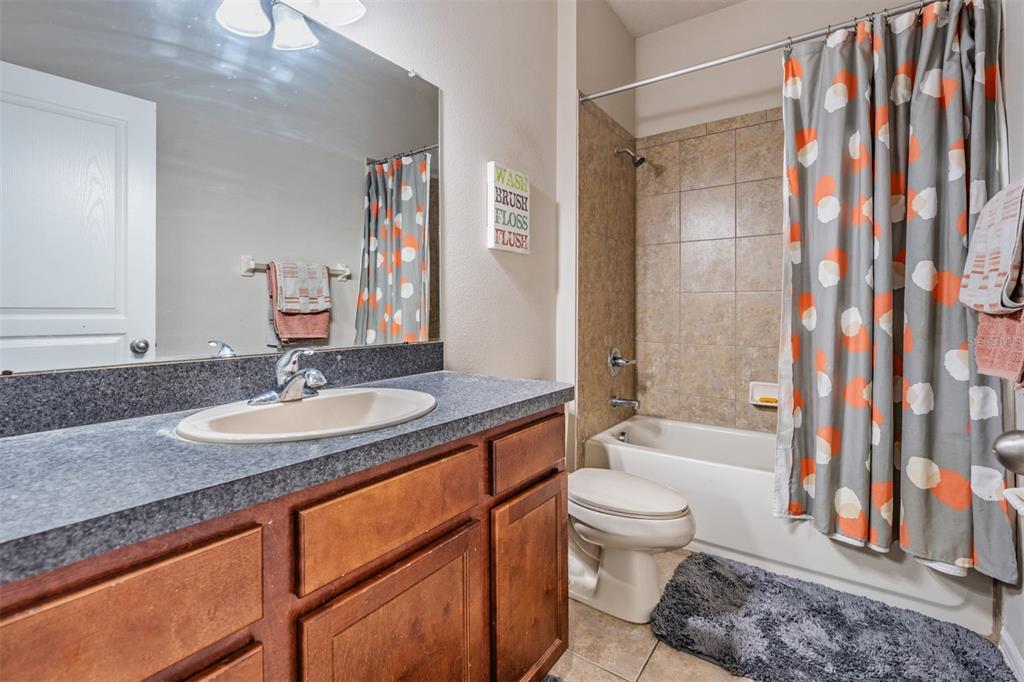 6908 Covington Stone Avenue Apollo Beach, FL 33572 - Photo 29 of 60 a bathroom with a granite countertop sink toilet and shower