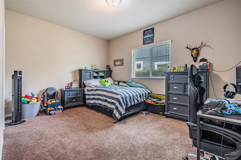 6908 Covington Stone Avenue Apollo Beach, FL 33572 - Photo 30 of 60 a bedroom with a bed and a tv