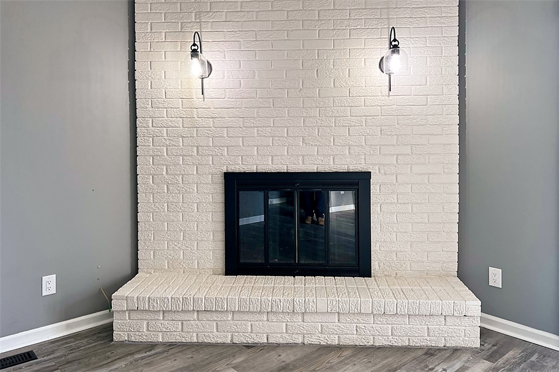 920 North Dorset Road, Unit 920 Troy, OH 45373 - Photo 5 of 18 This living room features a fireplace with a charming brick hearth and elegant sconce lighting.