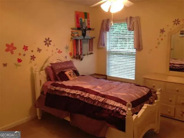 a bed sitting in a bedroom next to a window