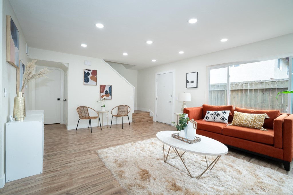 a living room with furniture and wooden floor