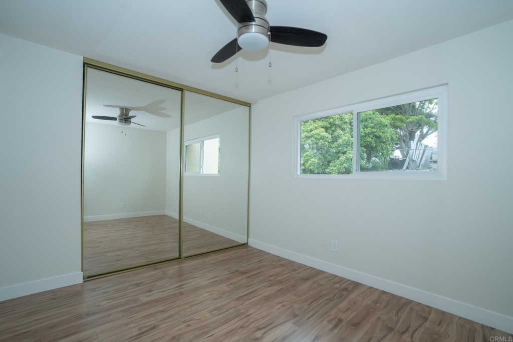 4080 Lake Boulevard Oceanside, CA 92056 - Photo 17 of 28 an empty room with wooden floor fan and windows