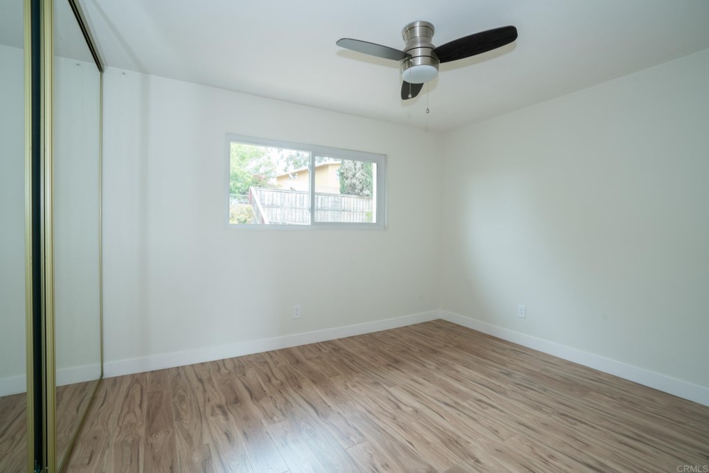 4080 Lake Boulevard Oceanside, CA 92056 - Photo 18 of 28 an empty room with wooden floor ceiling fan and windows