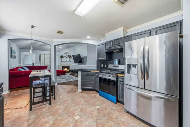 a kitchen with stainless steel appliances granite countertop a refrigerator sink and stove