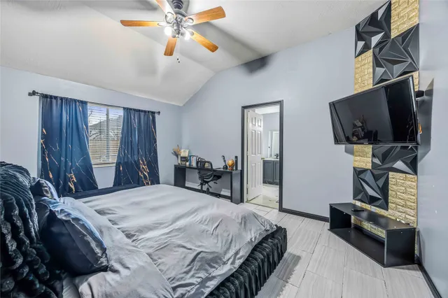 a bedroom with a bed a flat screen tv and dresser