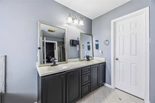 a bathroom with a double vanity sink and a mirror