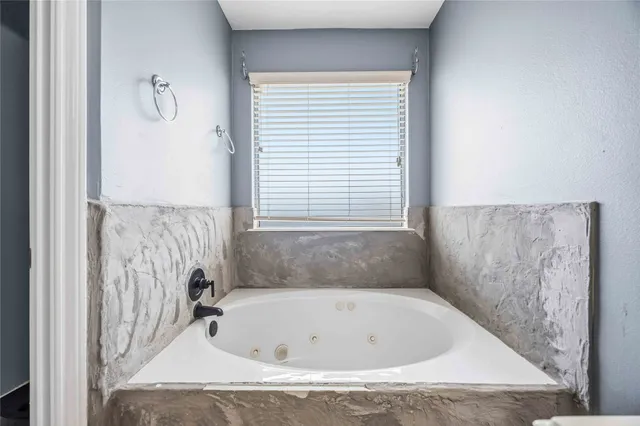 a bathroom with a tub and a window