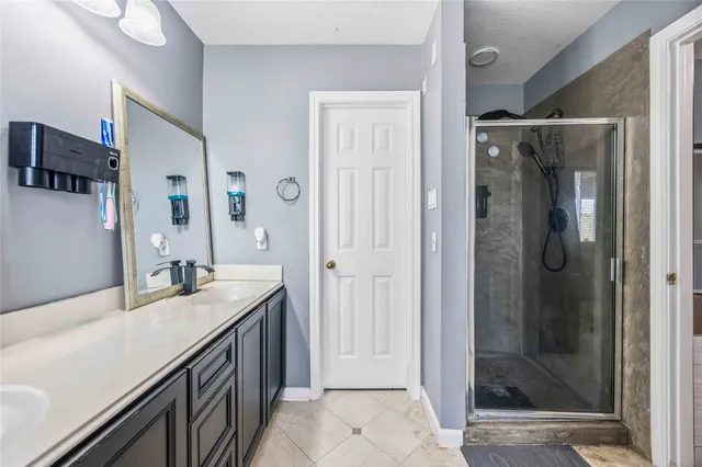 a bathroom with a granite countertop sink mirror and shower