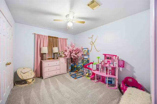 a bedroom with furniture and a chandelier fan