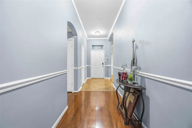 a view of a hallway with wooden floor and staircase