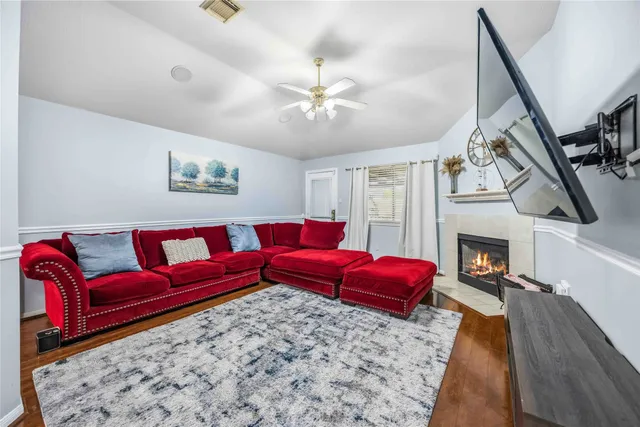 a living room with furniture a fireplace and a chandelier
