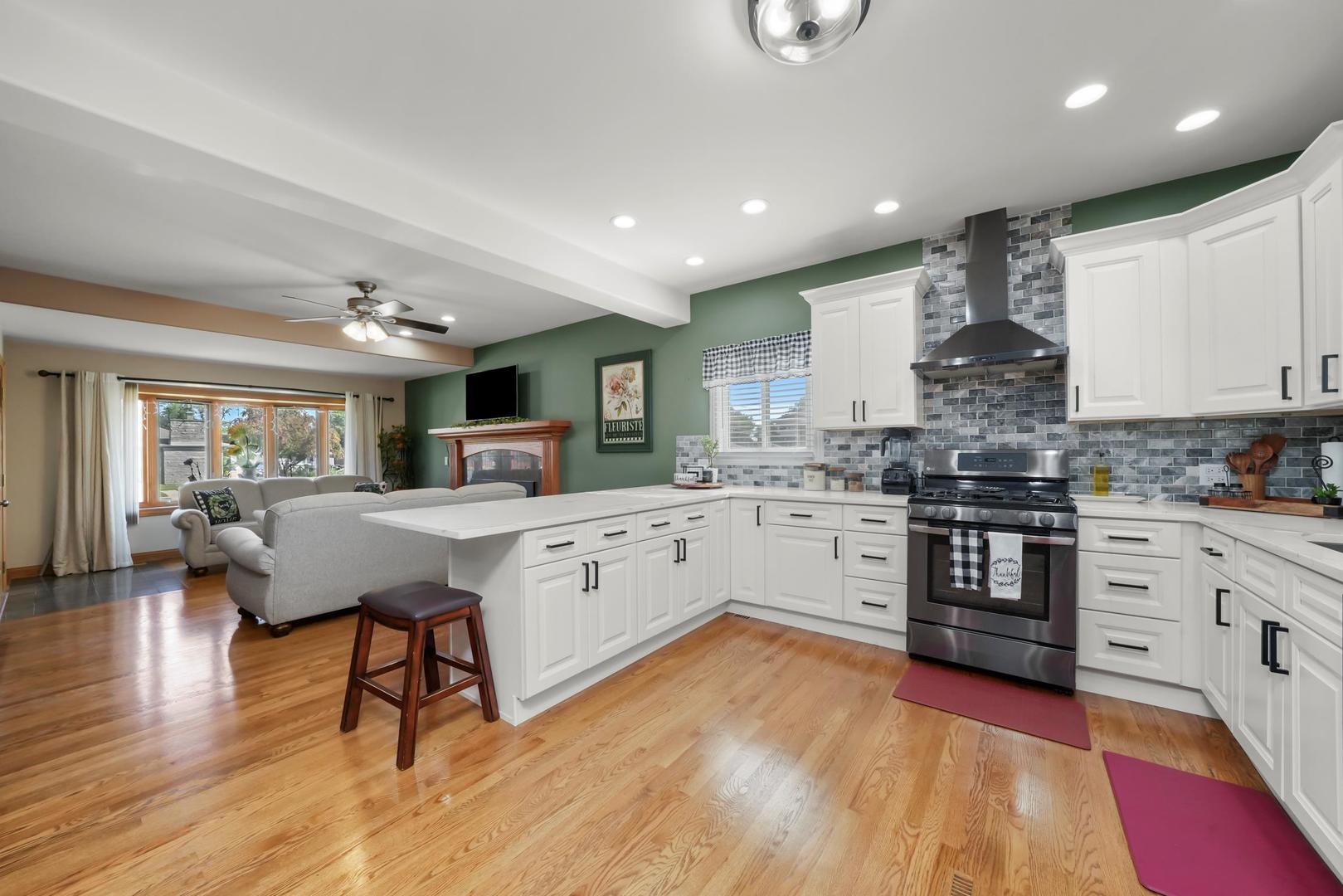 5907 West 109th Street Chicago Ridge, IL 60415 - Photo 13 of 45 a kitchen with stainless steel appliances granite countertop a stove top oven a sink dishwasher a dining table and chairs with wooden floor