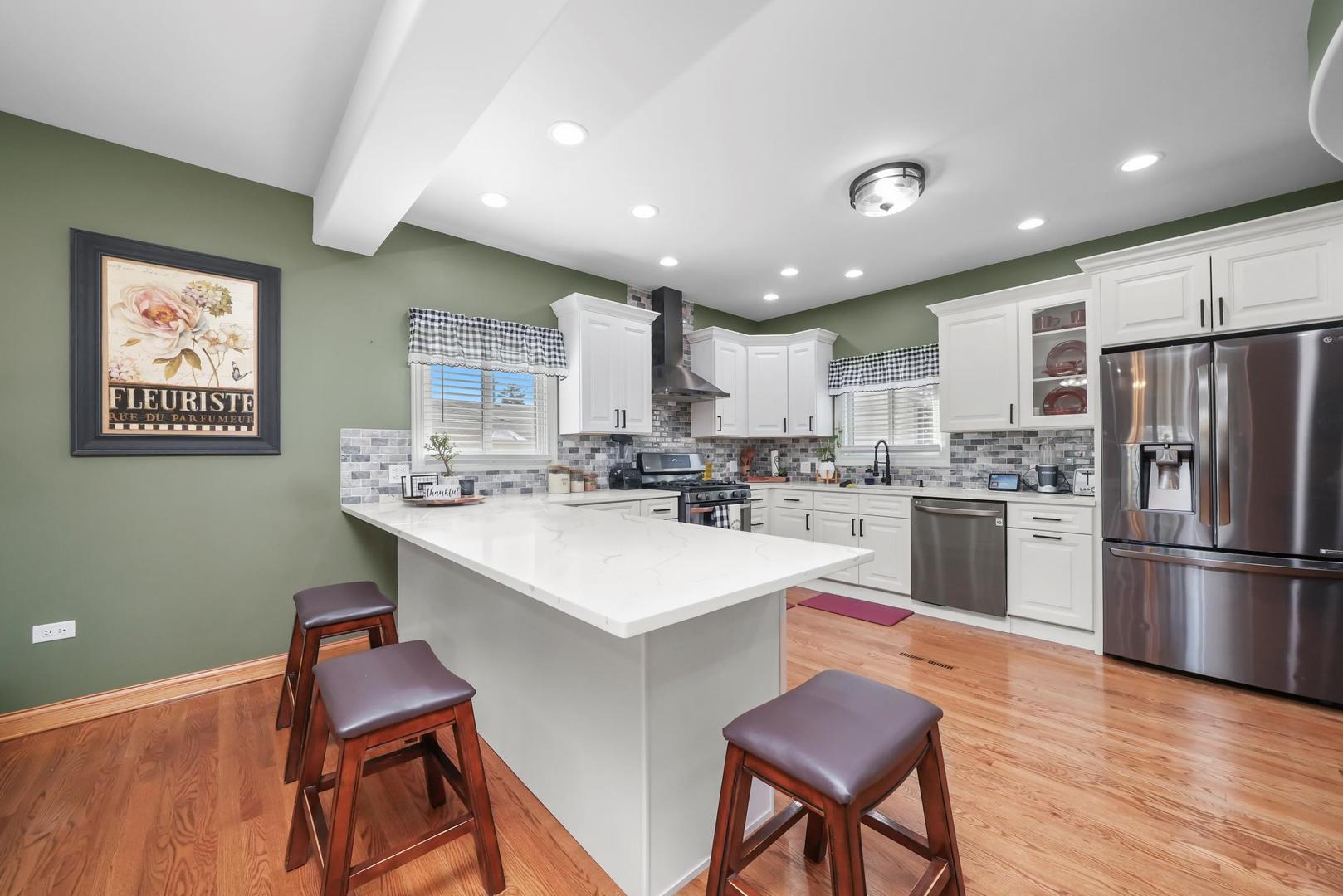 5907 West 109th Street Chicago Ridge, IL 60415 - Photo 15 of 45 a kitchen with stainless steel appliances granite countertop a sink a stove a refrigerator a microwave oven with a dining table and chairs