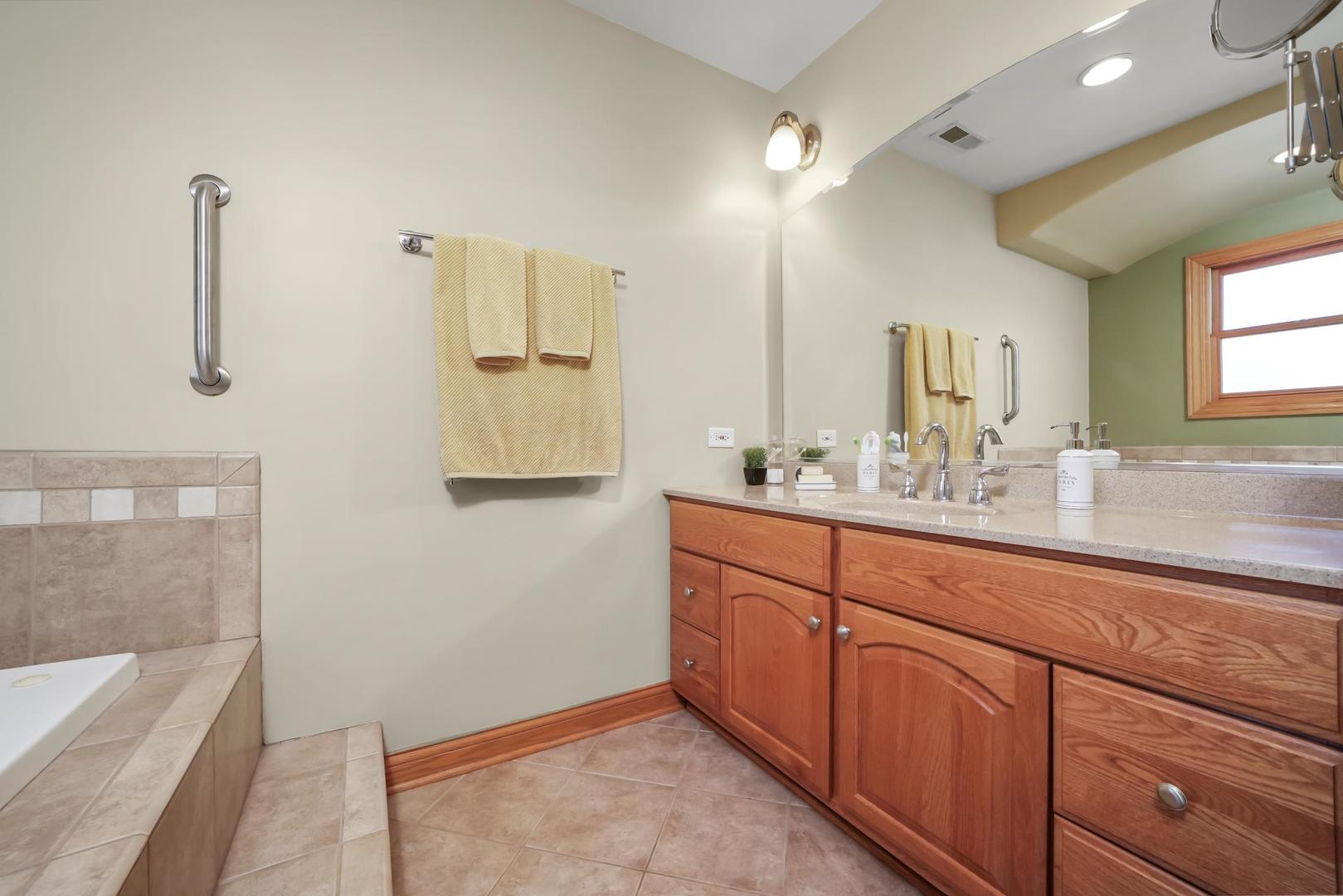 5907 West 109th Street Chicago Ridge, IL 60415 - Photo 23 of 45 a bathroom with a sink a large mirror and a bathtub