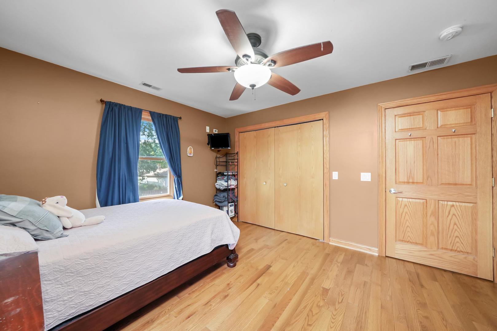 5907 West 109th Street Chicago Ridge, IL 60415 - Photo 25 of 45 a bedroom with a large bed and a chandelier
