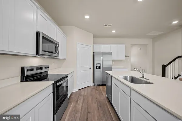 a kitchen with stainless steel appliances a stove sink microwave and cabinets