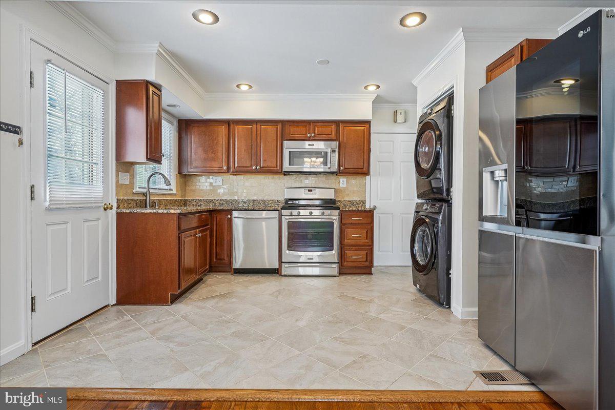7039 Calamo Street Springfield, VA 22150 - Photo 13 of 70 a kitchen with stainless steel appliances granite countertop a stove top oven a sink and a refrigerator
