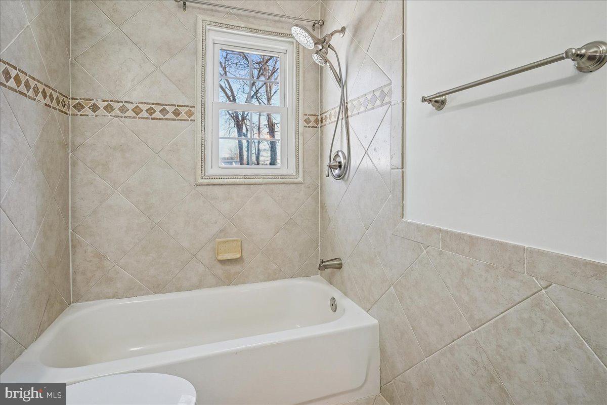 7039 Calamo Street Springfield, VA 22150 - Photo 31 of 70 a bathroom with a bathtub and shower