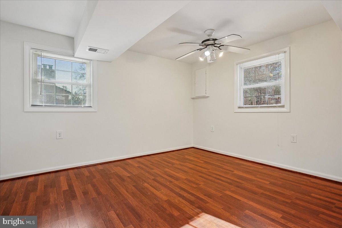 7039 Calamo Street Springfield, VA 22150 - Photo 42 of 70 a view of an empty room with wooden floor and a window